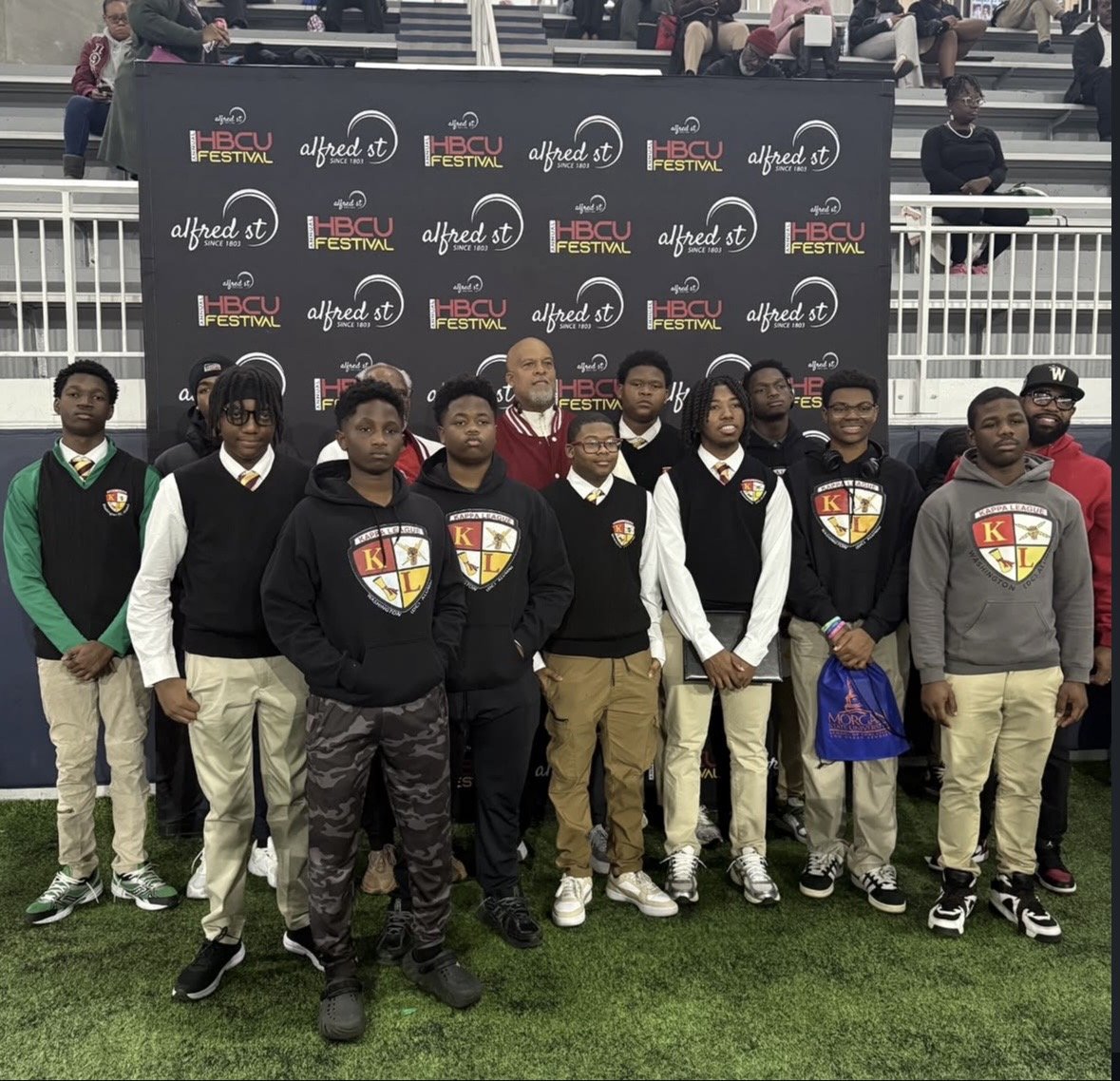 Kappa Leaguers seated in formal rows alongside mentor brothers in their crimson and cream blazers.